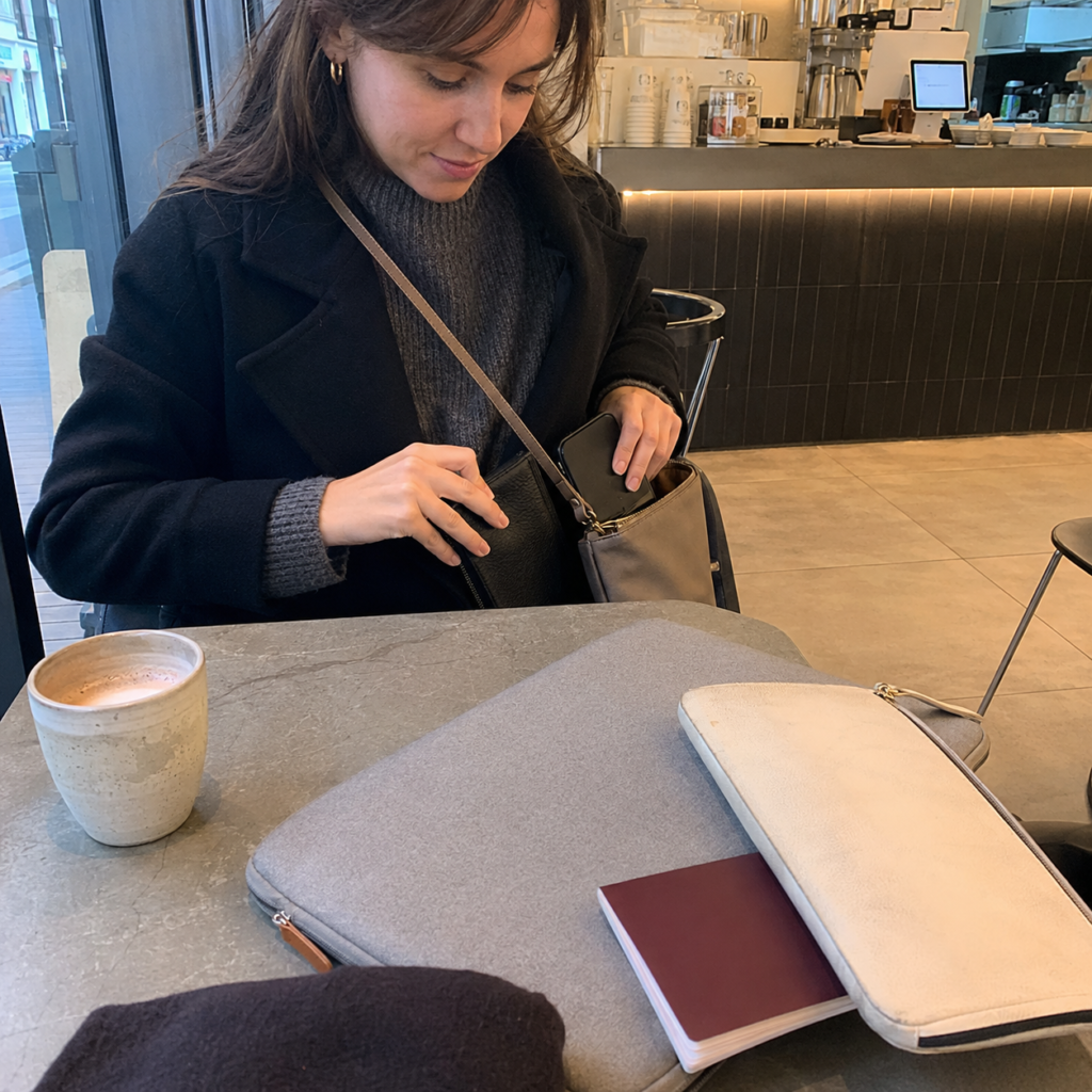 Traveler packing a laptop and valuables before leaving a Seoul cafe table