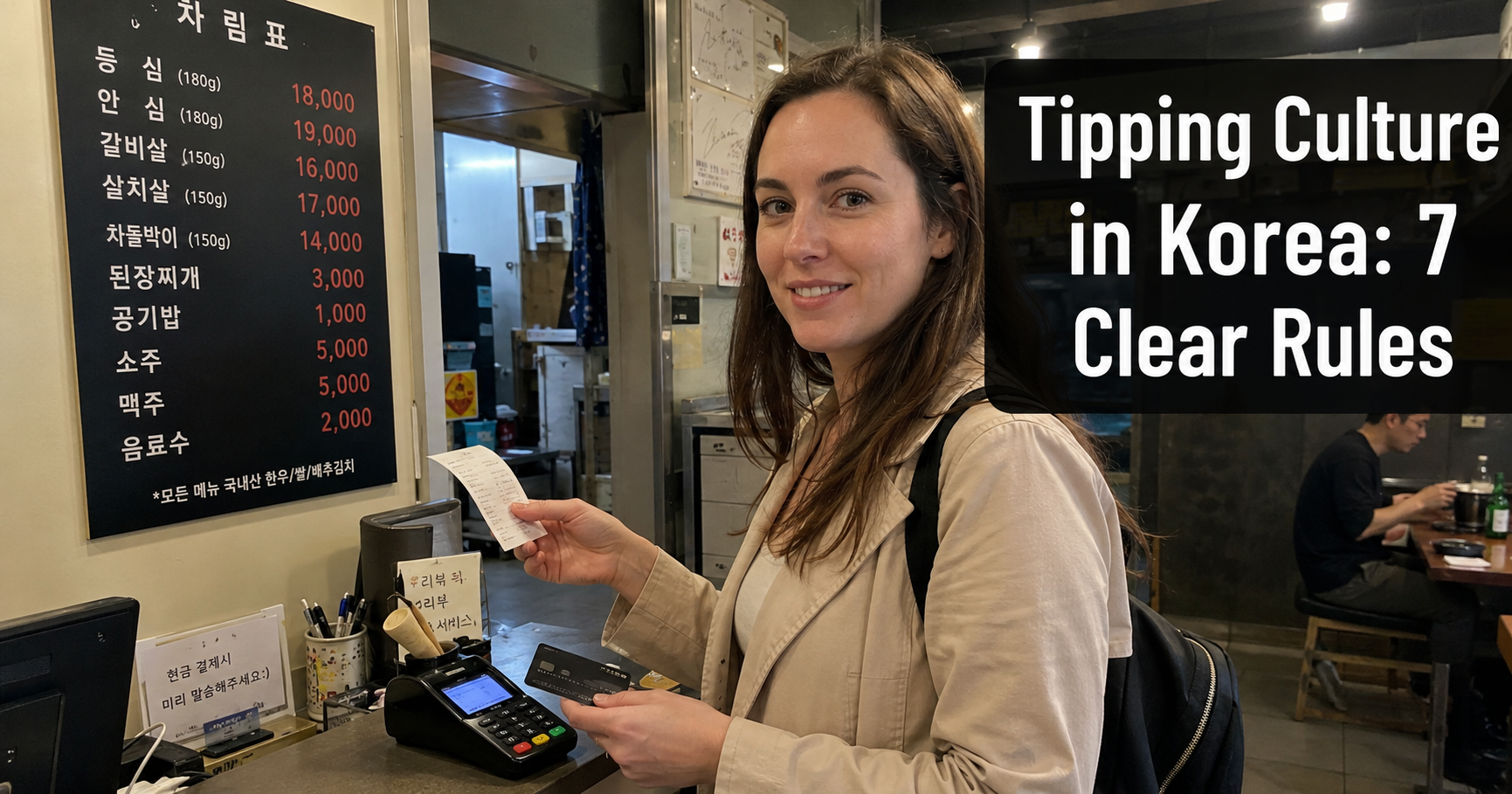 Traveler paying at a Korean restaurant counter.